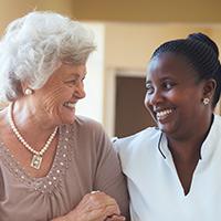 a nurse walking with an elderly lady down a hallway